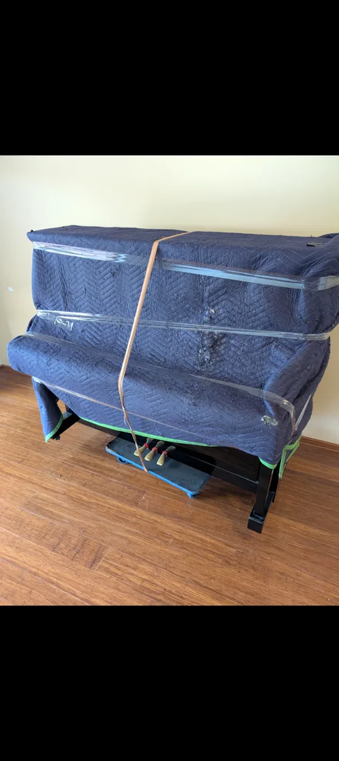 Piano wrapped in protective moving blankets